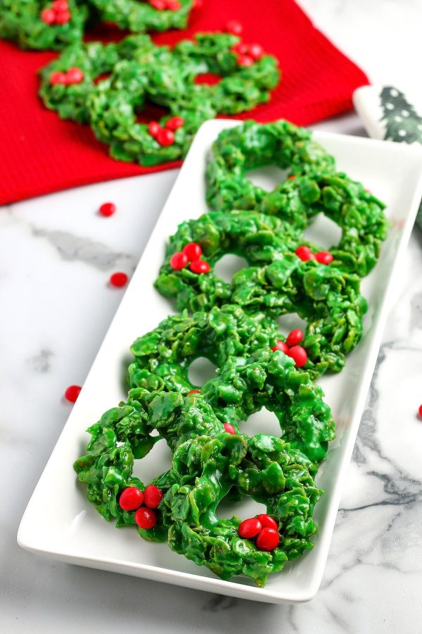 Corn flake wreath cookies with red candies on them.