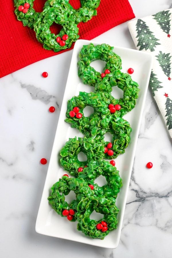 An overhead picture of the finished cornflake wreath cookies on a a white serving platter. 