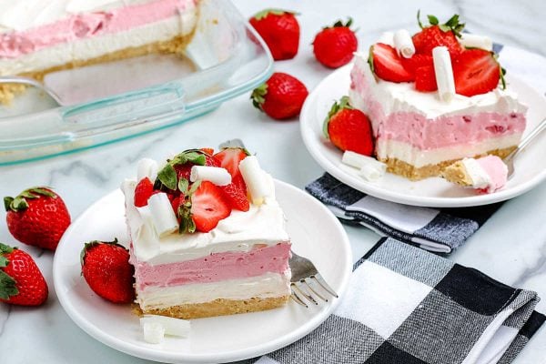 Two slices of Strawberry Lasagna on white plates.
