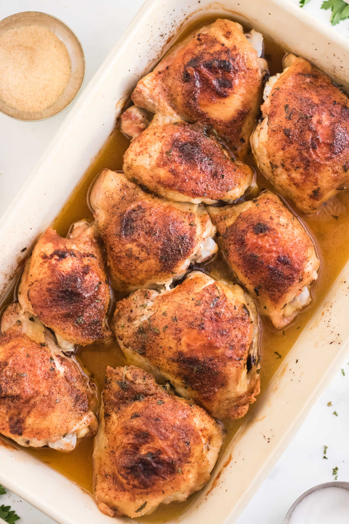 An overhead picture of the finished oven baked chicken thighs recipe in a white baking dish.