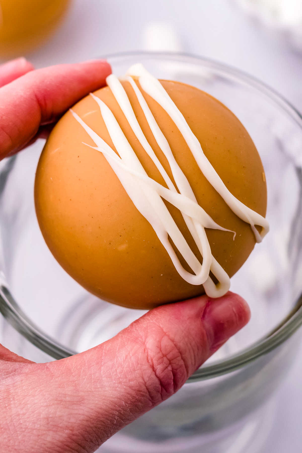 A close up picture of a finished Peanut Butter White Hot Chocolate Bomb.