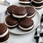 Chocolate Whoopie Pies stacked on a white plate.