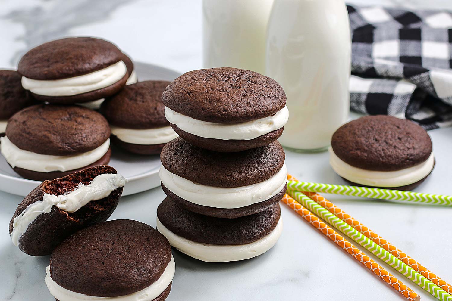 Chocolate Whoopie Pies stacked on top of each other and on a platter.