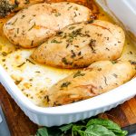 The finished Oven baked chicken breasts in a white pan.