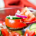 A spoon scooping up some of the Cucumber Tomato Feta Salad.
