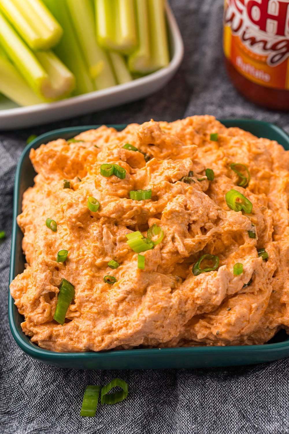 A close up picture of Keto Buffalo Chicken Dip in a green serving bowl. 