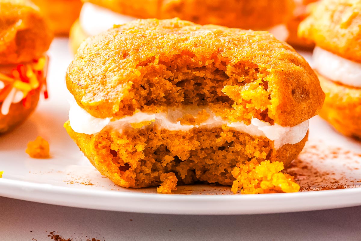A pumpkin whoop[ie pie with a bite taken out of it so you can see the moist interior. 