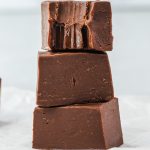 Three pieces of fudge stacked on top of each other, and the top piece has a bite taken out of it.