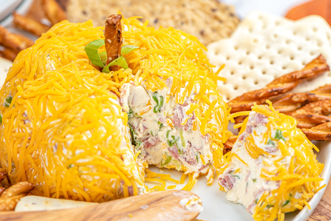 The finished fall cheese ball that has been cut into showing that is has salami and green onion in it.