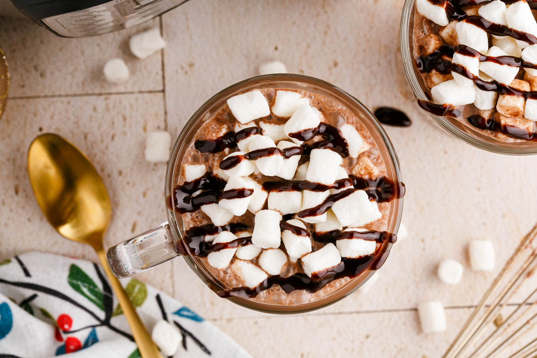 An overhead picture of the Instant Pot Hot Chocolate garnished with mini marshmallows and chocolate sauce.