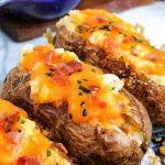 A close up picture of three finished Twice Baked Potatoes.