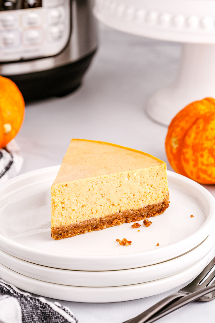 A slice of pumpkin cheesecake on a white plate.