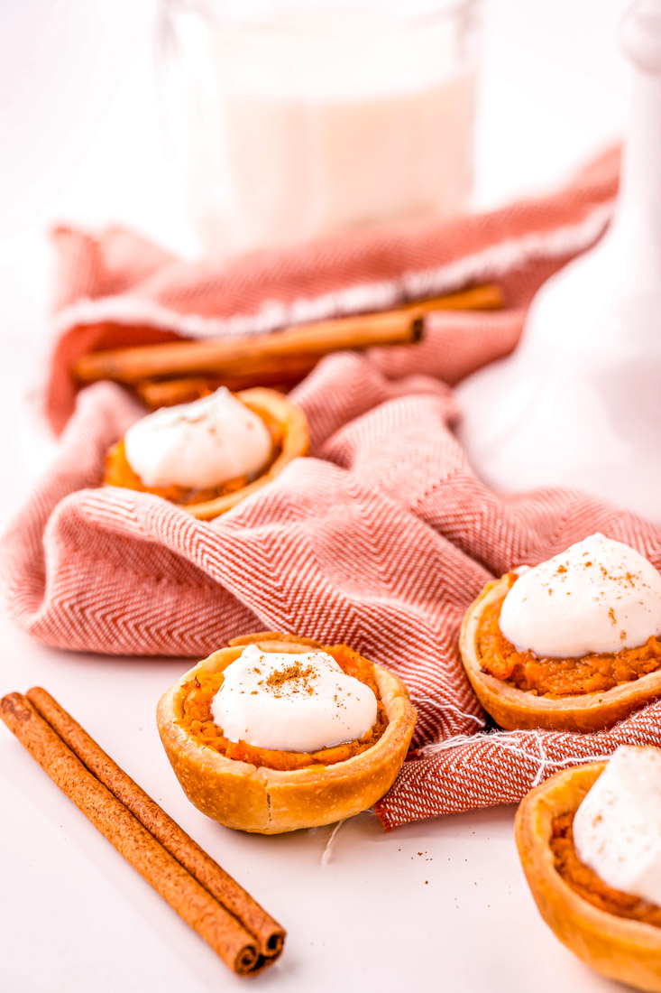 Mini Sweet Potato Pies on a countertop with a cinnamon stick in the background.