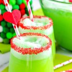 The finished Grinch Punch in glasses with the rims covered in red sugar sprinkles.