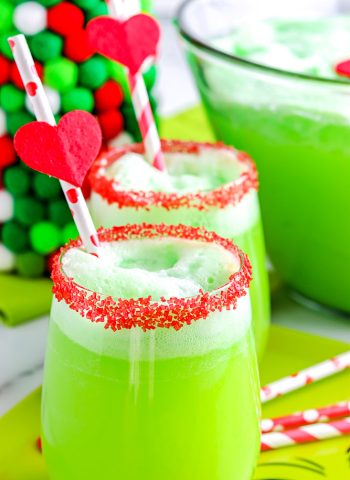 The finished Grinch Punch in glasses with the rims covered in red sugar sprinkles.