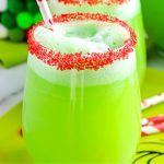 A close up picture of the finished Grinch punch in a clear class with lime sherbet floating on top.
