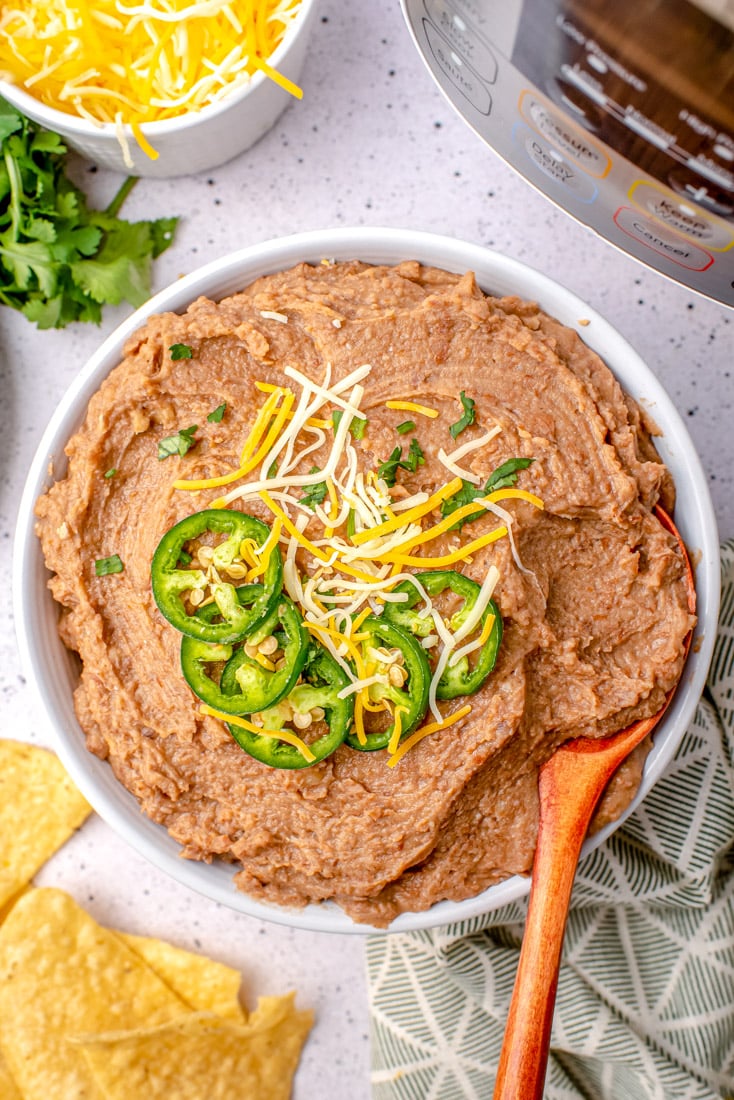 An overhead picture of the best Instant Pot Refried Beans in a white serving bowl.