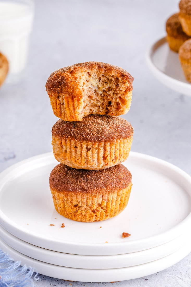 Three Banana Cinnamon Muffins stacked on top of each other and the top one is bitten into.