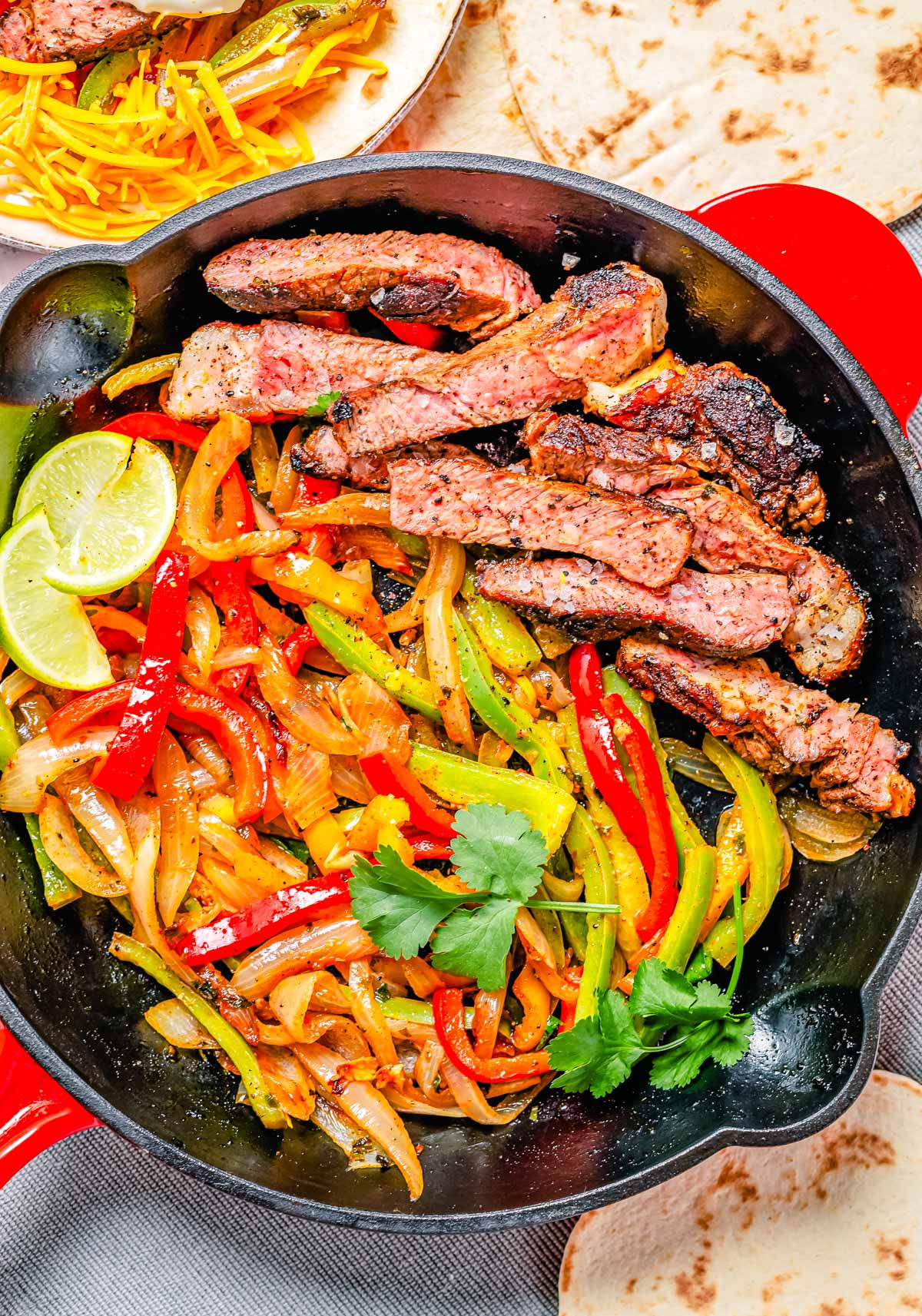 An overhead picture of the finished Steak Fajitas in a cast iron skillet. 