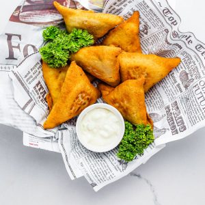 An overhead picture of the finished Vegetable Samosa recipe with dipping sauce.