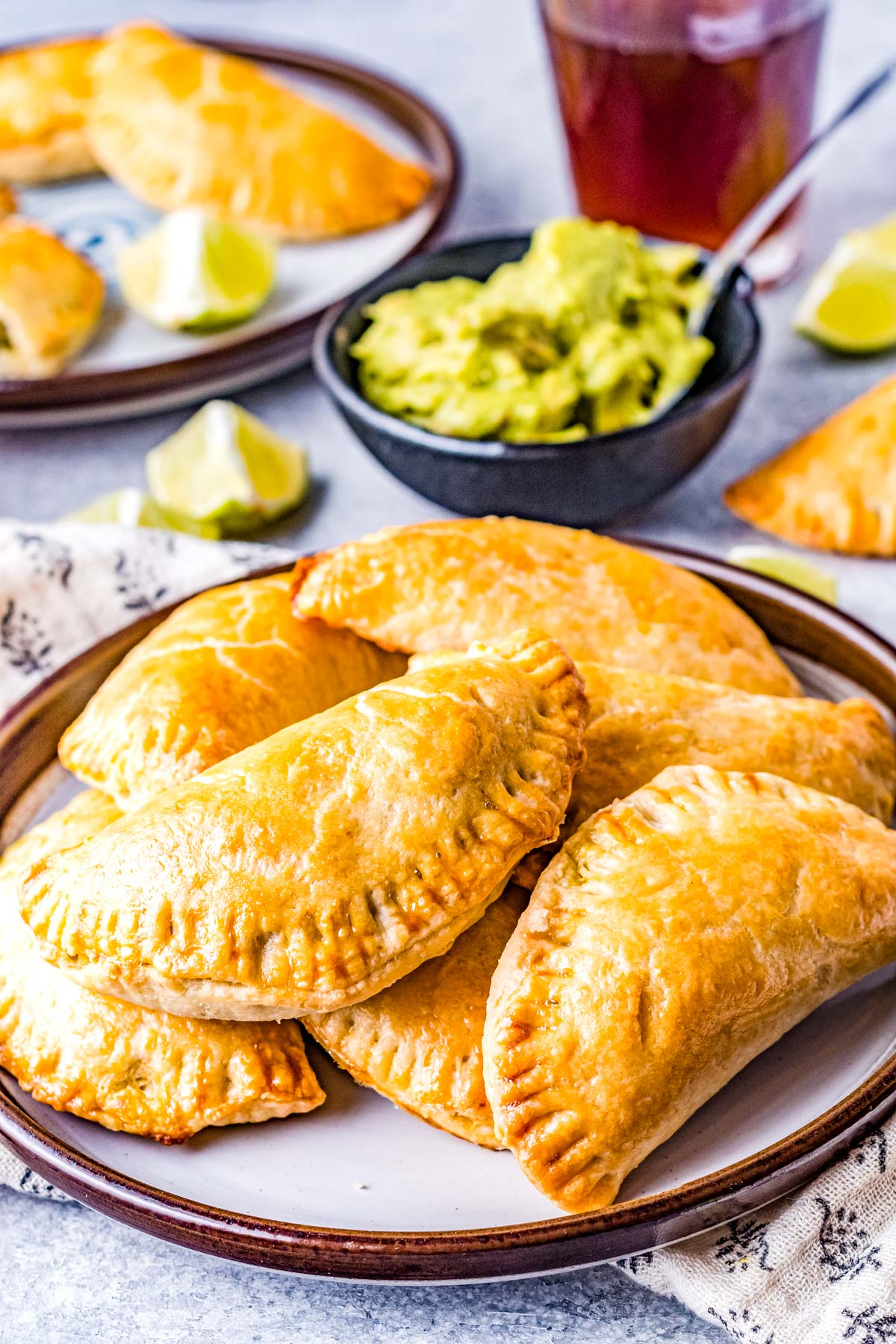 A pile of the finished Vegetarian Empanadas with some guacamole nearby.