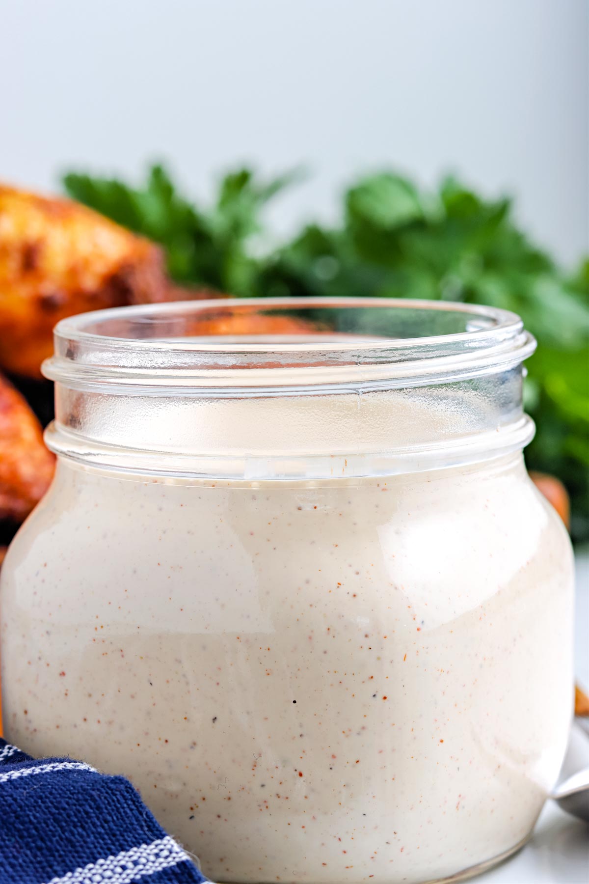 A close up of the finished Alabama White BBQ Sauce in a glass jar.