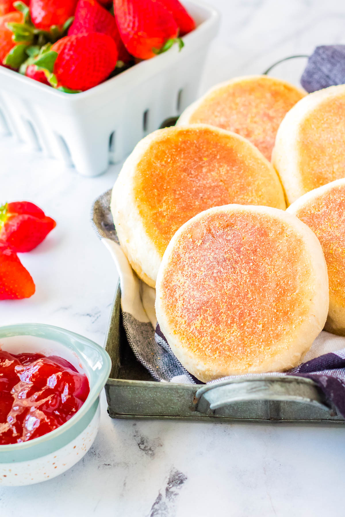 A close up picture of a basket of Homemade English Muffins.