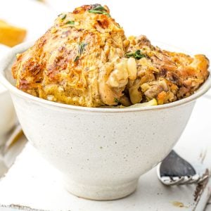 A serving bowl with some of the instant pot chicken thighs in it.