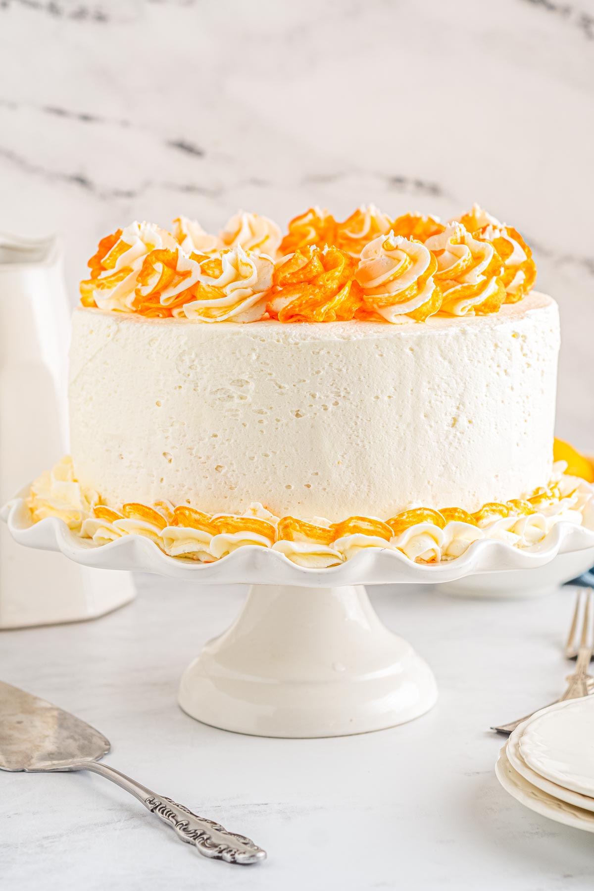 The finished Orange Creamsicle Cake on a white cake stand.