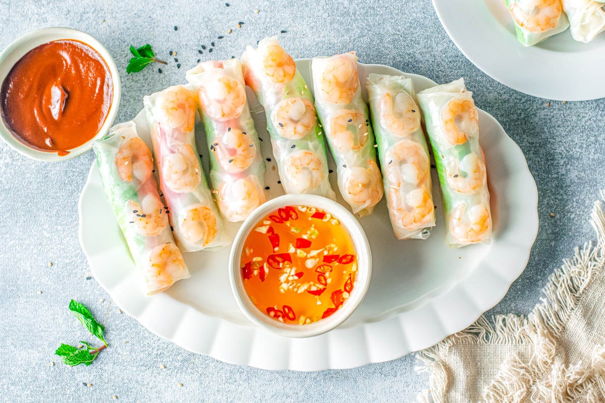 An overhead picture of the finished Vietnamese Summer Rolls on a serving platter with dipping sauce.