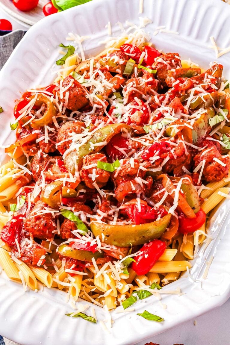 Pasta with Peppers, Onion, and Sausage in a white serving platter garnished with mozzarella.