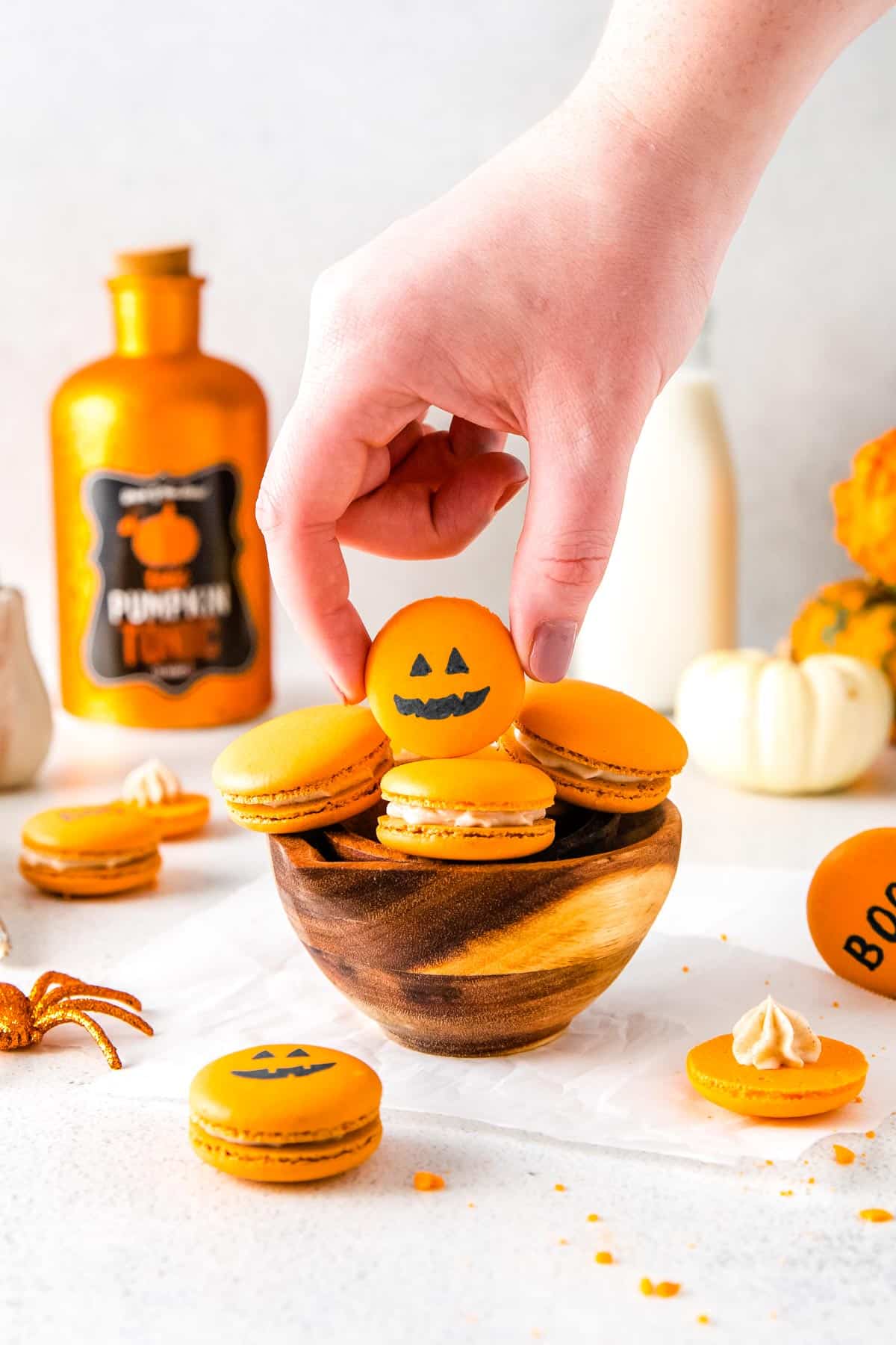 The Pumpkin Spice Macarons decorated with an edible black ink marker with a jar-o-lantern face for Halloween.