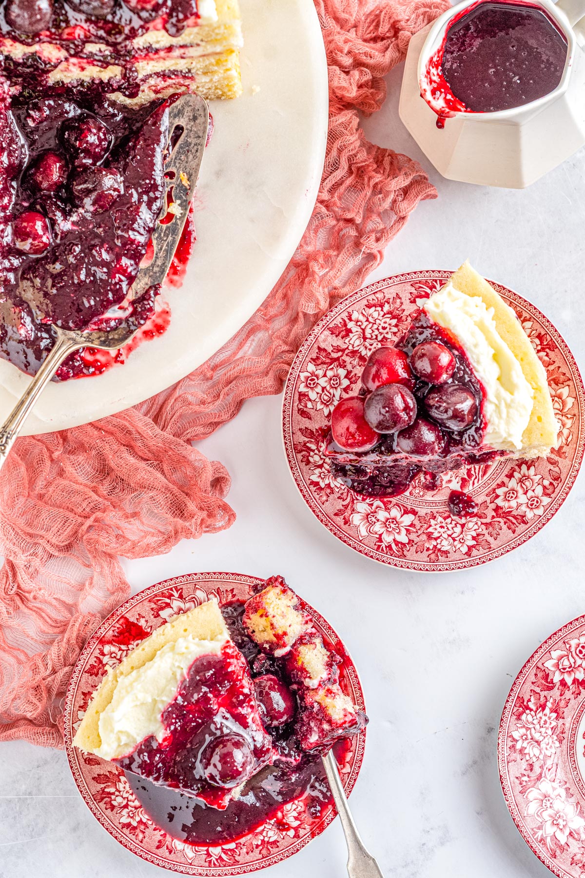 An overhead picture of slices of White Forest Cake on red plates.