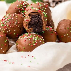 A close up picture of the finished Oreo Balls for Christmas, one with a bite taken out of it so you can see the interior.