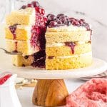 A close up picture of a slice of take being taken out of the finished White Forest Cake recipe.