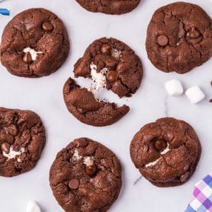 A Chocolate Marshmallow Cookie broken in half so you can see the gooey marshmallow center.