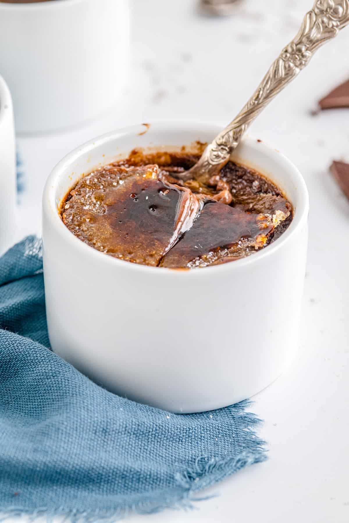 A spoon in a pot of the finished Chocolate Creme Brulee recipe.