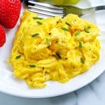 A close up picture of finished Scrambled Eggs recipe on a white plate.