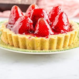 the finished recipe for anStrawberry Tartlet on a green and white plate.