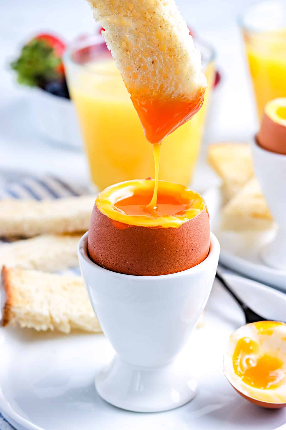 Toast being dipped into the soft boiled egg yolk. 