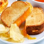A close up picture of an Air Fryer Grilled Cheese Sandwich on a white plate.