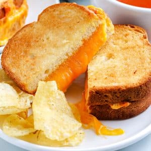 A close up picture of an Air Fryer Grilled Cheese Sandwich on a white plate.
