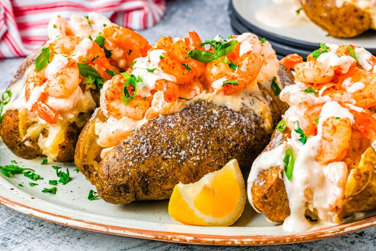 Three Baked Potatoes With Shrimp on a serving platter.