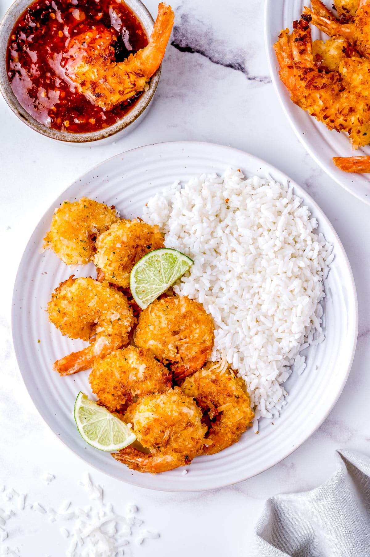 An overhead picture of the fried coconut shrimp on a plate with white rice.