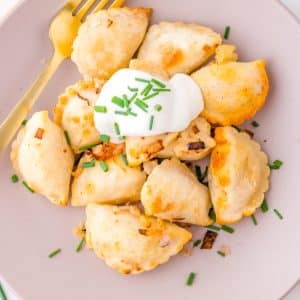 A close up picture of a pile of pierogis made in an air fryer on a plate.