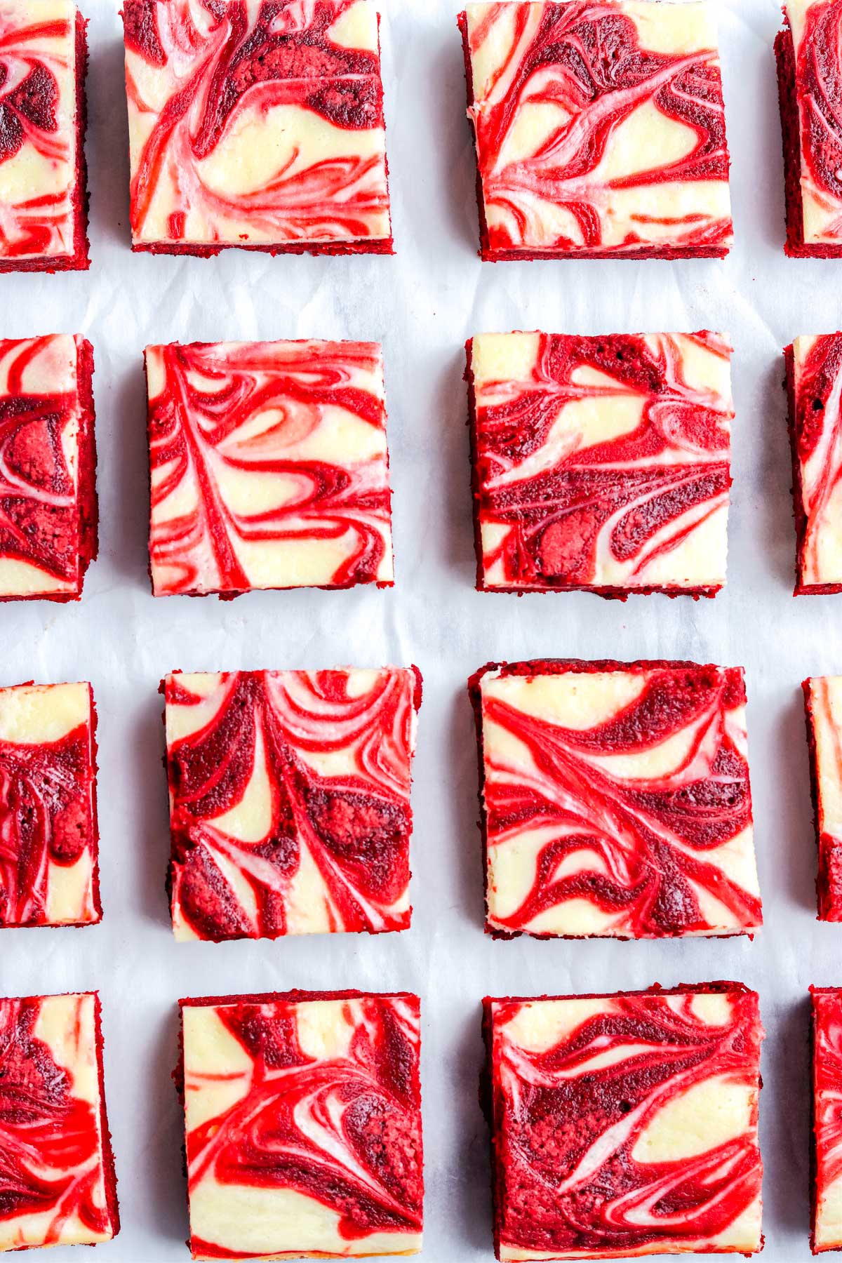 Rows of red velvet swirl brownies photographed closely to highlight the marble pattern and vibrant color contrast.