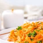 A close up picture of French Carrot Salad on a white plate.