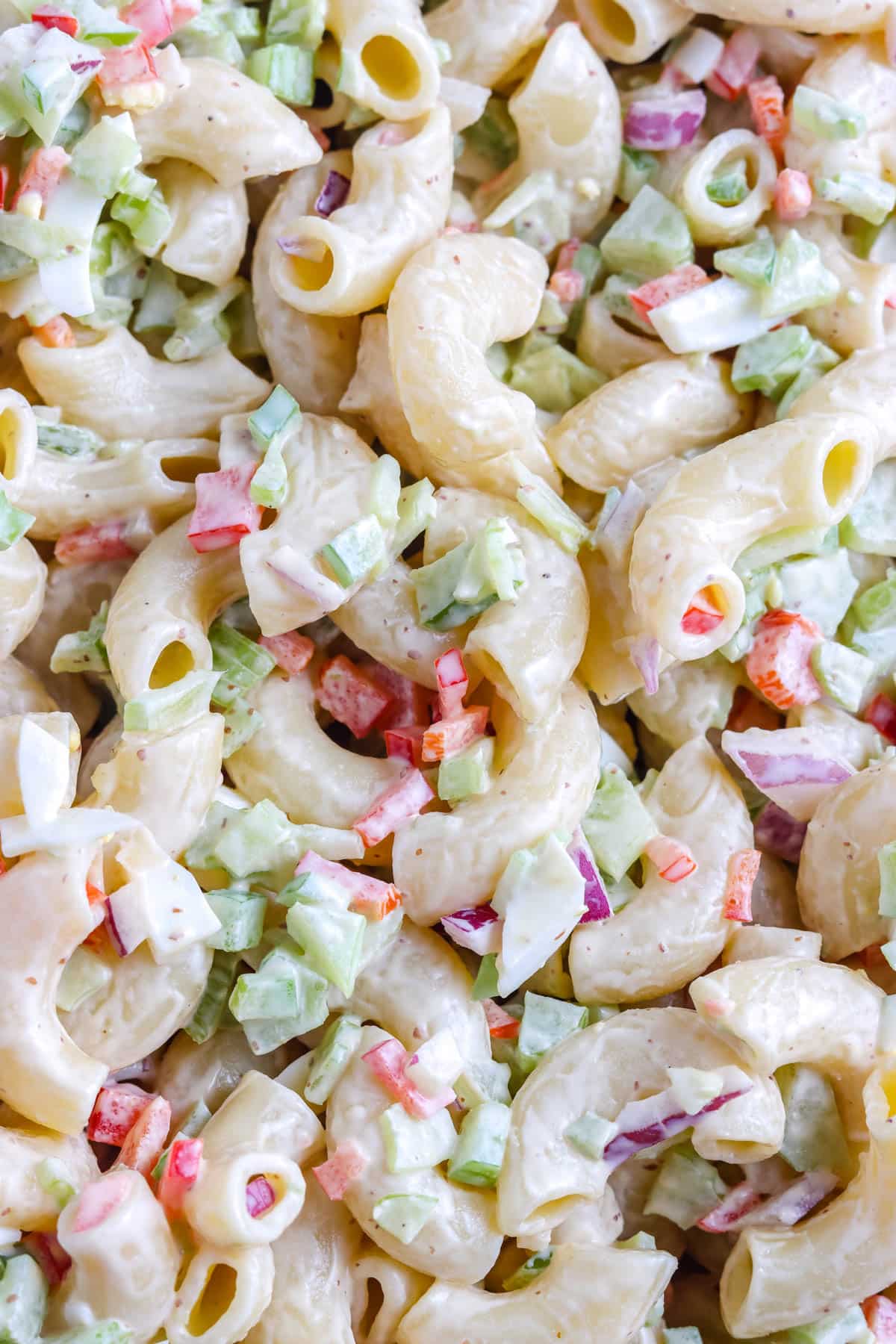 A close up picture of Deli Macaroni Salad so you can see the texture of the soft pasta and small chopped veggies.
