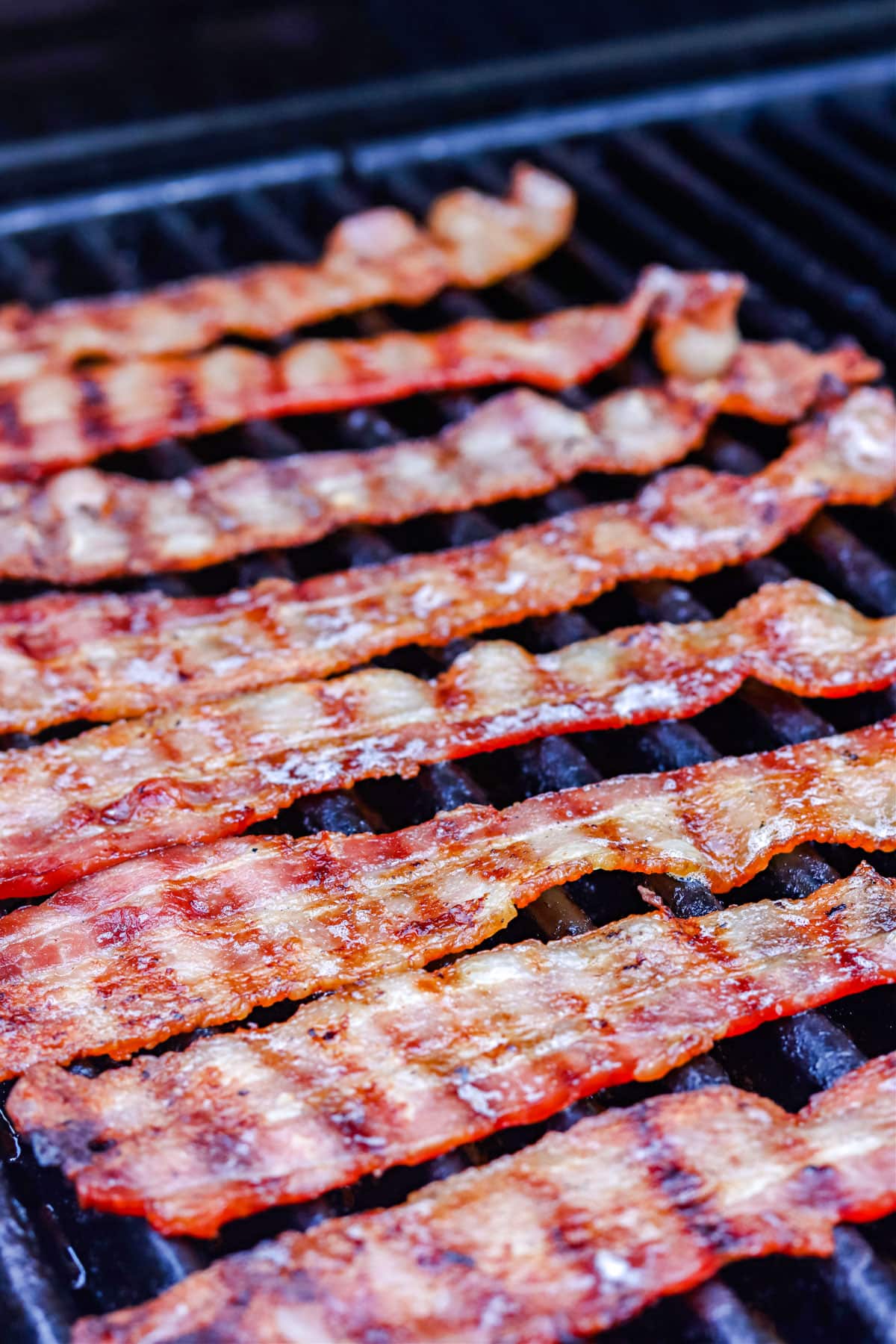Bacon on the grill with grill marks on the bacon.
