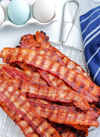 A pile of Grilled Bacon on a serving board.